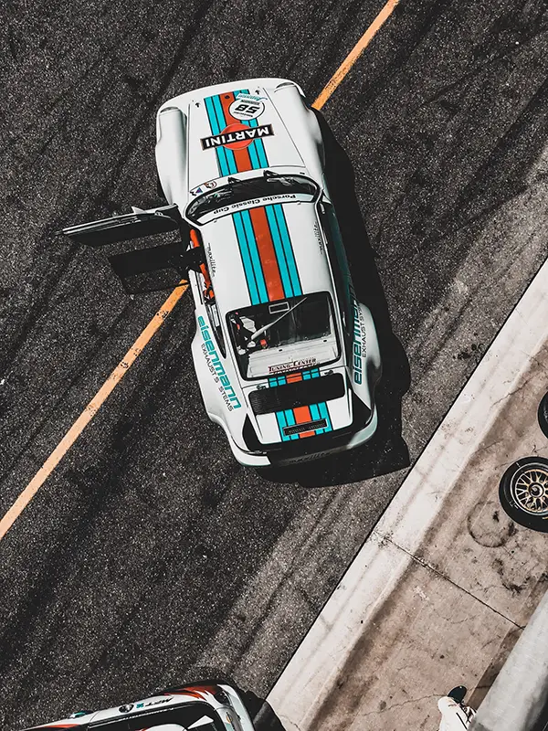 Photographie de Victor Theo d'une voiture de course automobile Porsche via Unsplash.