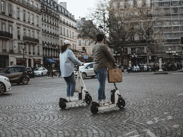 Personnes roulant en trottinettes électriques.