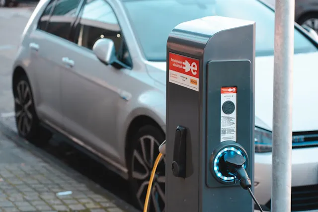 Voiture électrique branchée à une borne de recharge.